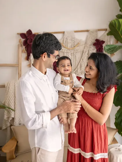 A family of three, with the parents looking lovingly at their smiling son in the middle. A classic portrait that radiates warmth and happiness.
