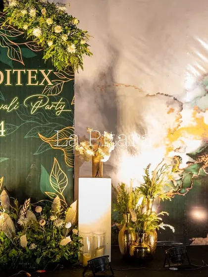 A close-up of the custom-branded backdrop for the Inditex Diwali Party 2024. The elegant design featured gold leaf illustrations on a deep green background, perfectly reflecting a modern and festive corporate style.