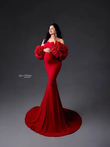 Motherhood and high fashion go hand in hand. This bold red mermaid gown with floral sleeves creates a glamorous and unforgettable silhouette.