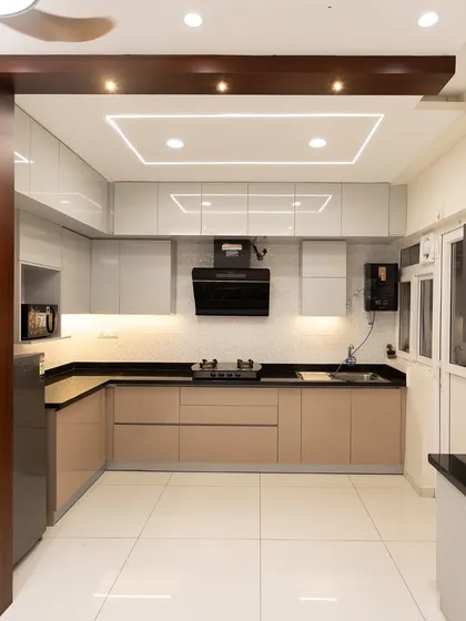A wider view of the beige kitchen, showing how it connects to the rest of the home. The clean lines, glossy finish, and smart layout create a space that is both beautiful and highly functional.