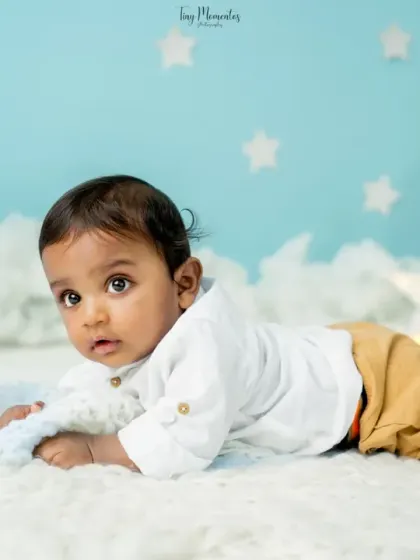 A close-up of his sweet face during tummy time. The soft lighting and dreamy backdrop make this baby portrait feel magical.