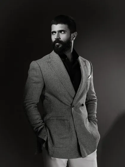 A black and white version of Vijay Deverakonda's portrait, which emphasizes the texture of the houndstooth pattern and the sharp contrast of the styling.