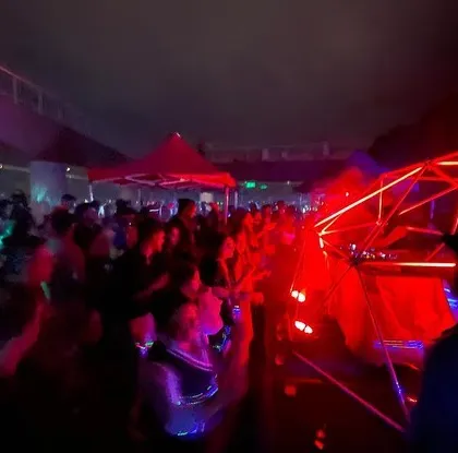 A wide shot of the incredible party atmosphere in Bangalore. The entire venue, packed with people, is glowing red from the unique lighting production we set up for the night.