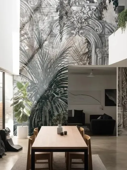 This striking wallpaper combines classical architectural elements with monochrome palm leaves. The high-contrast, layered design creates a unique and sophisticated look for a modern, open-plan space.