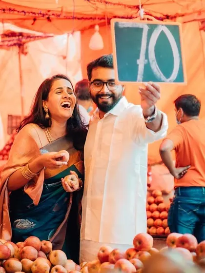 A fun and candid moment captured in a fruit market during a pre-wedding shoot. The genuine laughter makes this a memorable and authentic photograph.