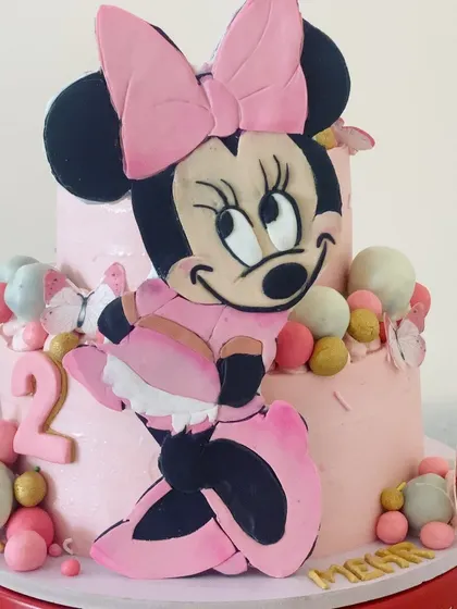 A close-up on the star of the show: the hand-painted and sculpted 2D Minnie Mouse topper, showcasing the detailed line work and cheerful expression.