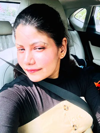 A car selfie showing a layered beige and black top, highlighting a casual but put-together look.