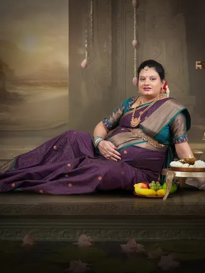 A regal, seated portrait. The mom-to-be looks like royalty, surrounded by offerings of fruit and light in this beautifully composed traditional scene.