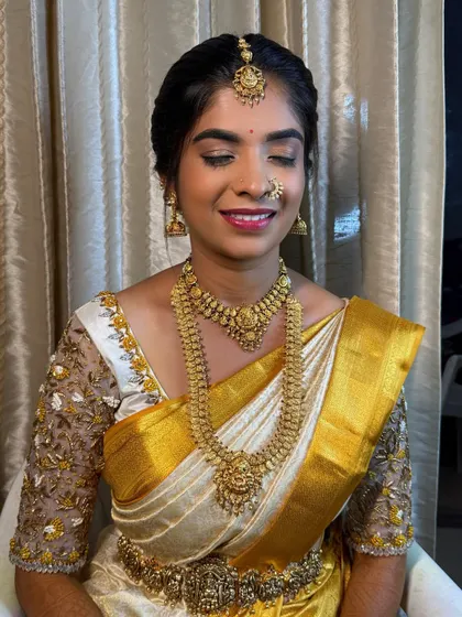 A classic muhurtham look for my bride Shanthala. The makeup features soft glam eyes and a bright lip, perfectly complementing her white and gold silk saree.