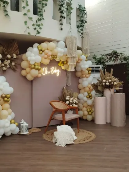 A chic and modern boho baby shower. This 'Oh Baby' setup features a neutral color palette, macrame hangers, pampas grass, and a stylish neon sign.
