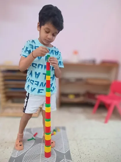 Working with the color cylinders, this child is learning to grade colors from darkest to lightest. This sensorial activity sharpens their visual perception and gives them the language to describe the world in more detail.