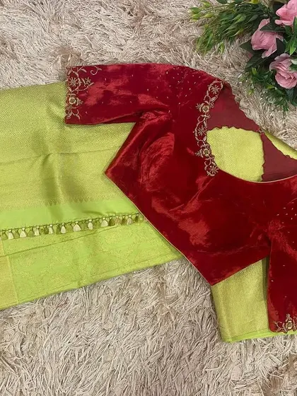 A classic red velvet blouse with delicate gold katdana embroidery, paired with a lime green silk saree for a striking contrast.