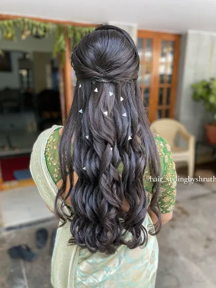 A half-up style with voluminous curls, decorated with scattered triangular silver clips. This is a unique and geometric take on hair accessories, creating a modern look.