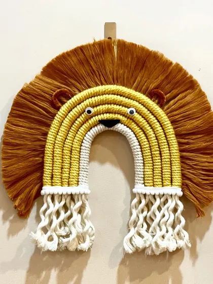 A close-up of my lion rainbow wall hanging. The design combines the shape of a rainbow with the features of a lion, including a fluffy mane and cute little ears.