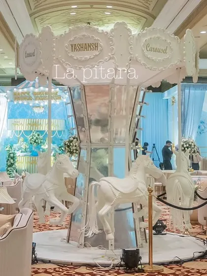 The carousel centerpiece integrated seamlessly with the guest seating area, which featured comfortable white lounge furniture, allowing guests to enjoy the magical atmosphere up close.
