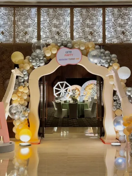 The entrance to Arrham's party, with a balloon arch and giraffe props welcoming guests to the celebration inside.