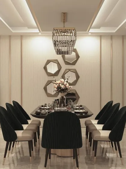 An elegant 8-seater dining setup with black velvet chairs and a sleek table. The wall is adorned with hexagonal mirrors, adding a geometric and reflective element to the room.