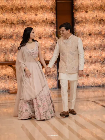 The couple walking hand-in-hand, perfectly framed by the elegant architecture of the venue.