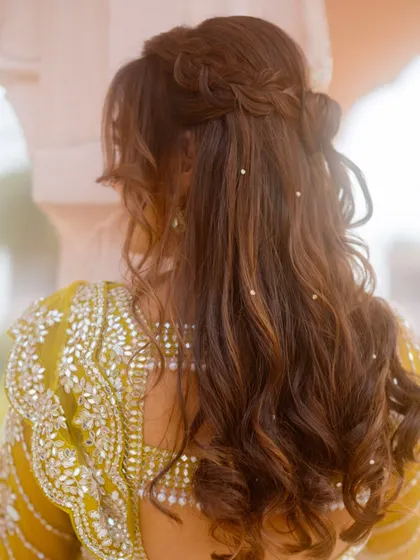 The back view of her beautiful half-up hairstyle with pearl details, perfect for the carnival theme.