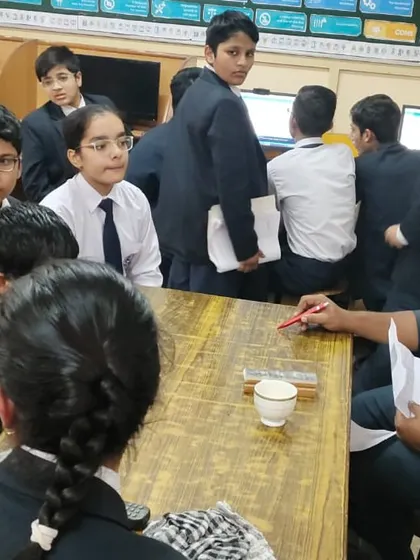 An instructor engages with a group of curious students, explaining a complex concept in a simple and accessible way.