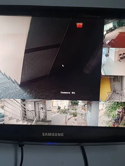 This monitor shows feeds from a Hikvision camera system in an apartment building, covering the staircase, lobby, and parking area.