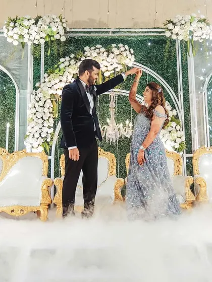 A fairytale moment from the reception. The couple shares their first dance on a stage filled with smoke, surrounded by sparklers.