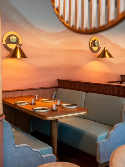 The details matter. From the custom light fixtures to the textured walls, every element is chosen to create a warm and inviting dining environment.