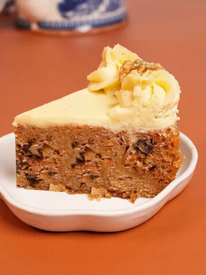 A perfect slice of my Carrot Walnut Tea Cake. This winter favorite is full of warm spices, freshly grated carrots, and crunchy walnuts, all topped with a delicious cream cheese frosting.