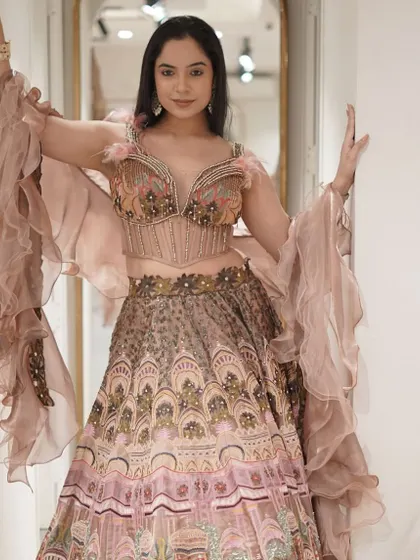 Reign in vibrant splendor! This show-stopping embellished lehenga with a daring corset-style blouse and dramatic ruffled sleeves is perfect for a fashion-forward bridesmaid.