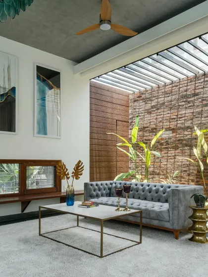 The formal living room is designed with biophilic principles, set amidst an indoor garden and opening up to views of the pool and surrounding landscape.