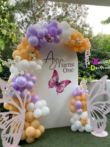 A wider shot of the outdoor butterfly setup, showing how the decor creates a stunning focal point against a natural green background.