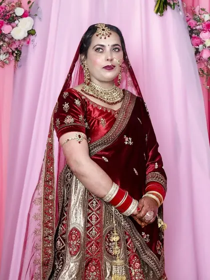 A full-length portrait of the bride against a lovely pink floral backdrop, perfect for a wedding reception.