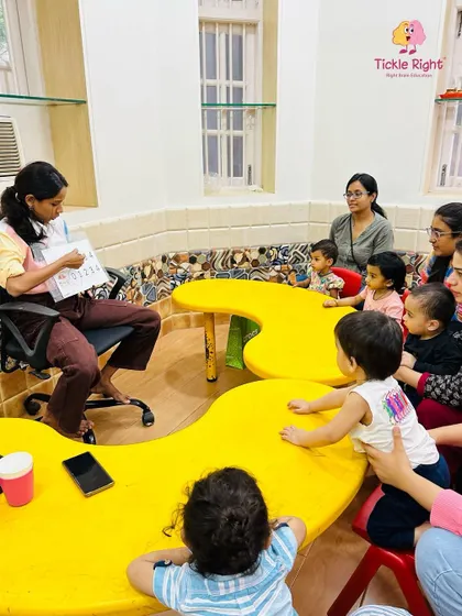 A trainer sits with a group of attentive children, their eyes fixed on the learning material. This image captures the engaging and focused atmosphere we cultivate in every session.