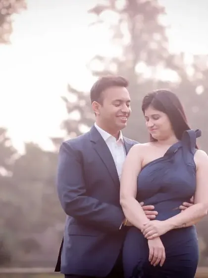 A romantic pre-wedding portrait with a soft, hazy background. The couple's gentle embrace and the beautiful light create a serene and intimate mood.