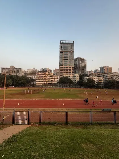 A wide view of our synthetic track and the surrounding field, with the city skyline in the distance. This shows the scale of our facilities and our unique urban location.