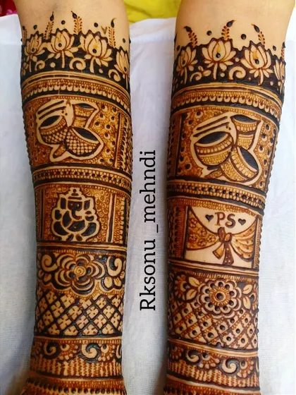 A detailed view of the forearm panels from a bridal design. It showcases motifs like the dhol, Ganesha, and a personalized wedding invitation, telling the story of the celebration.