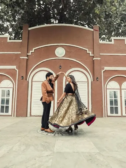 A wide shot of the couple dancing, showcasing the grand architecture of the studio backdrop.