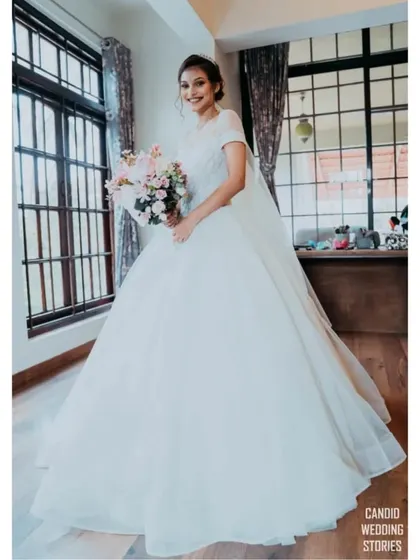 A full-length portrait of a Christian bride in her beautiful white gown, looking elegant and ready for her big day.