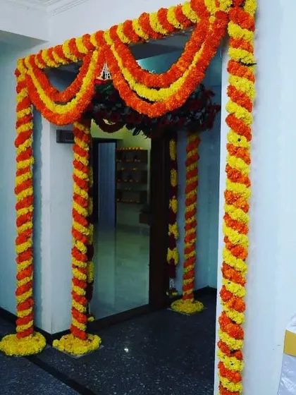 This is another example of a beautiful and traditional marigold decoration for a home entrance. The twisted garlands of yellow and orange genda phool create a classic and auspicious welcome for your guests.