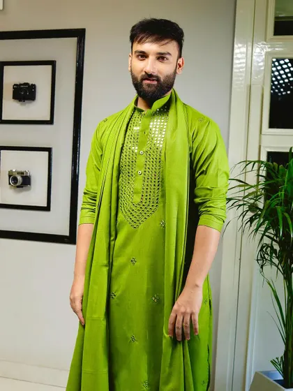 Make a vibrant statement with this green kurta set. The chest is adorned with intricate hand-applied mirror work, adding a touch of festive sparkle to the rich color.