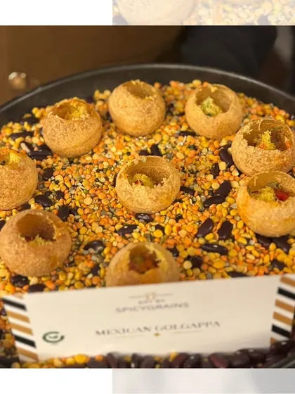 A creative fusion of Mexican and Indian flavours. These Mexican Golgappas are filled with a tangy salsa mix and presented on a bed of colourful lentils.