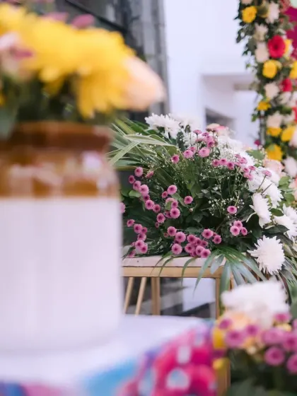 A close-up of colorful floral arrangements in traditional ceramic jars, adding a rustic and vibrant touch to a Mehendi function in Jim Corbett.