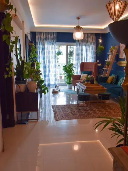 A wider view of the living room with the new summer curtains. Notice how they complement the blue wall and the green plants, creating a cool and calming oasis.