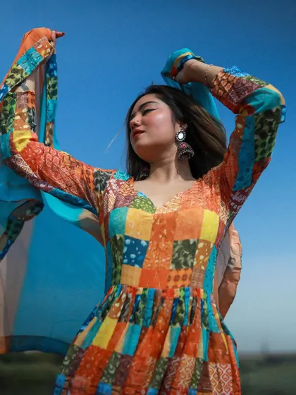 A close-up of the model with her dupatta in the air, capturing a moment of pure freedom and happiness.