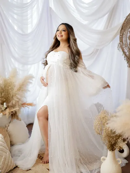 A duplicate of image 302, this radiant portrait shows a mom-to-be in a beautiful white pearl-studded gown, glowing with happiness.