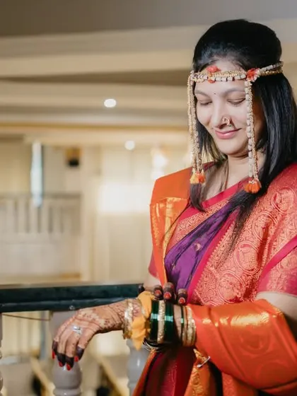A lovely portrait of the bride on the balcony, her traditional mundavalya and saree beautifully captured.