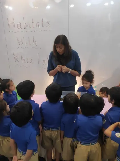 The children are captivated as the instructor explains the different layers of a habitat, using a model to make the lesson visual and easy to understand.