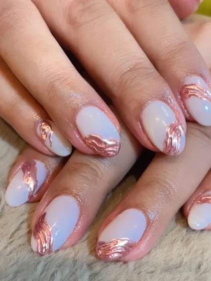 A modern and artistic design. A milky white base is adorned with abstract rose gold chrome strokes, creating a chic and sophisticated look.