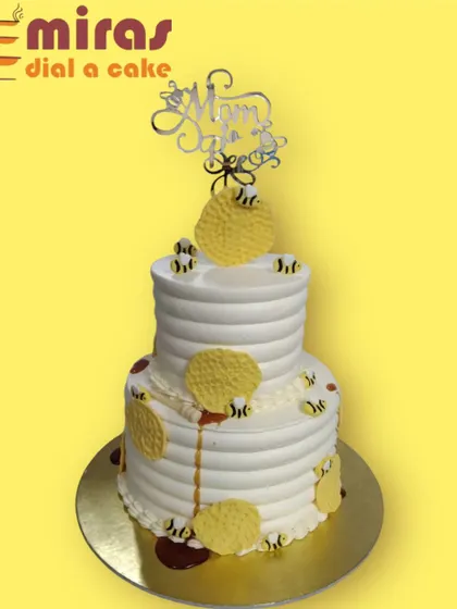 A "Mom-to-Bee" themed baby shower cake. This two-tier cake is buzzing with excitement, decorated with honeycombs and tiny edible bees for a sweet and clever theme.