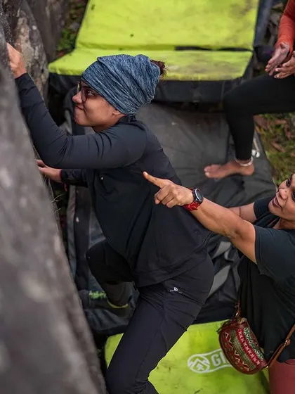 An instructor offers a gentle guide to a climber, showing the hands-on, supportive coaching you'll receive at our events.